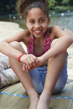 Mixed race girl relaxing near lake