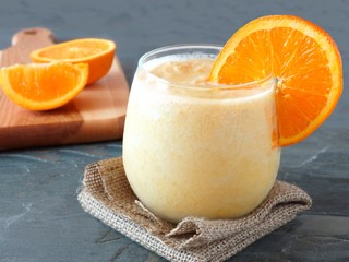 Healthy orange fruit smoothie in a stemless glass