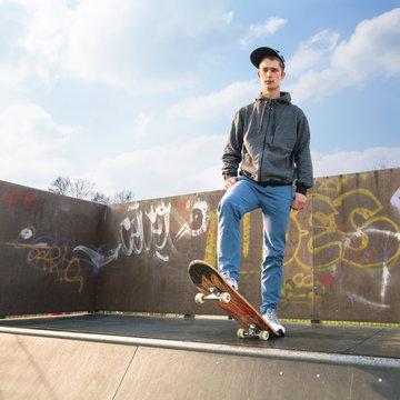 Teenage boy standing on a skateboard in a skate park