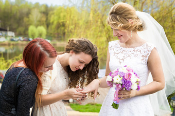 happy bride showing wedding ring to bridesmaids