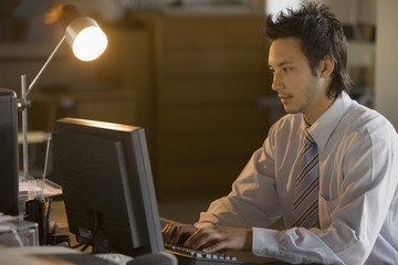 Asian businessman typing on computer