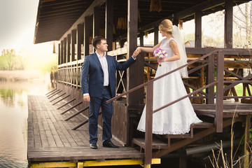 bride and handsome groom walking down the stairs on pier © Kyrylo Ryzhov