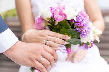 Obraz na płótnie Canvas Closeup of bride and groom holding beautiful bridal bouquet