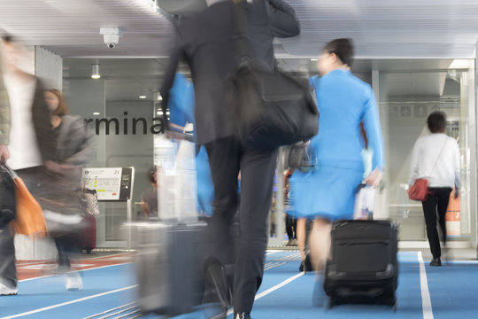 空港イメージ　スーツケースを持って歩く人々　スローシャッター