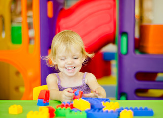 Child  playing with bright plastic construction blocks
