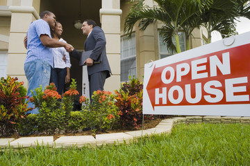 African couple shaking hands with Hispanic real estate agent