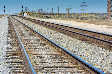 Obraz premium Railroad tracks lead to a parked train