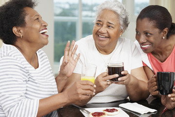 African American mother and adult daughters at breakfast