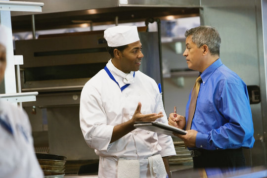 Hispanic businessman talking to chef
