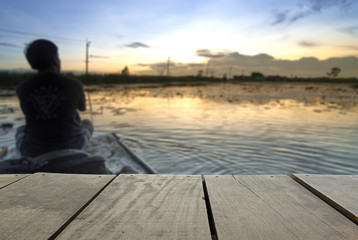 Blur image of terrace wood and Lonely man sitting on boat