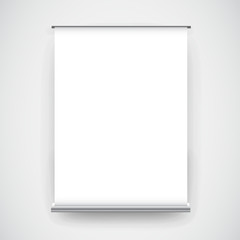 Empty white roll up banner display on wall