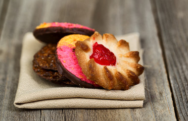 Stack of assorted cookies in cloth napkin on wood