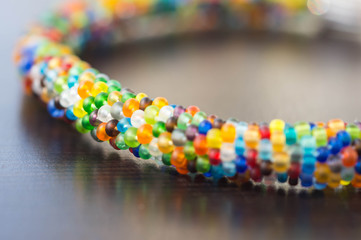 Knitted bracelet from small multi-colored beads close up