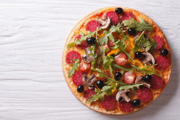 Italian pizza with rucola and salami, horizontal top view
