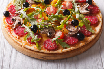 Hot Italian pizza with herbs, salami and vegetables