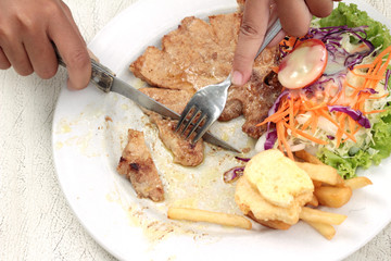 steaks and vegetable salad with french fries.