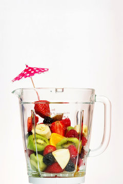 Various fruits inside smoothie blander glass.