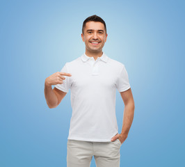 smiling man in t-shirt pointing finger on himself