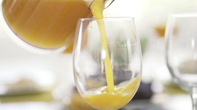Pouring orange juice into glass
