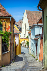 Old stone paved street with tourists from Sighisoara fortress