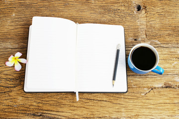 Notebook and black coffee on wooden table