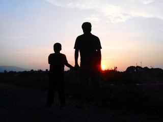 Fototapeta na wymiar silhouette father and son in sunset