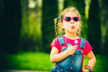 Haappy little girl with candy outdoor in the park