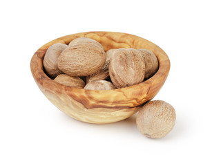 whole dried nutmegs in bowl, isolated