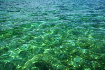 Blue shallow sea with coral reef and fluffy clouds on the horizon.