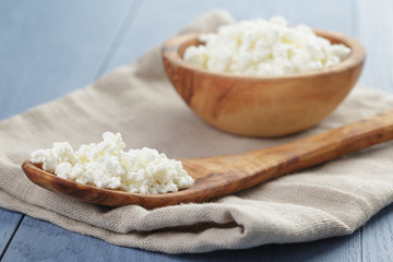 cottage cheese in wood bowl on blue wooden table