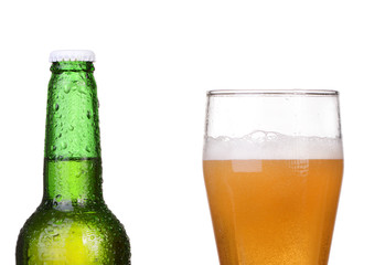 Chilled green bottle with condensate and a glass of beer 
