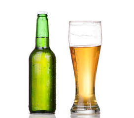 Chilled green bottle with condensate and a glass of beer lager 