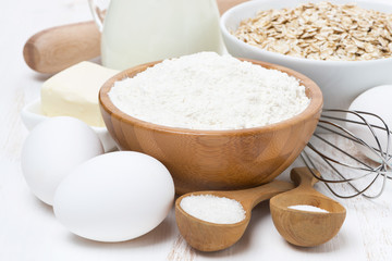milk, cereal and ingredients for baking on wooden table