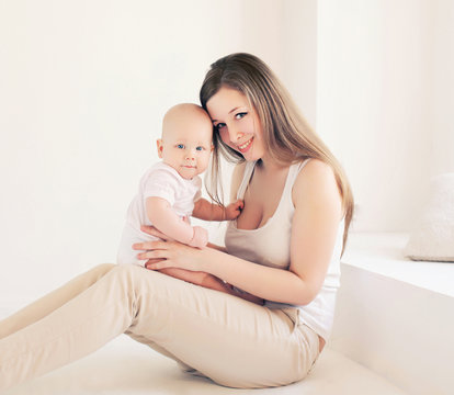 Young mother and baby at home in light room