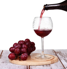 wine pouring into glass with grape and bottles isolated