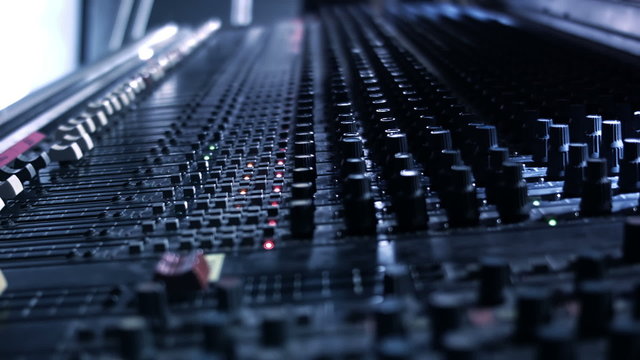 Audio Engineer sticking tape to his mixing console desk