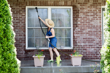 Housewife washing the windows of her house - 82980535