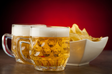 Glasses of beer with potato chips
