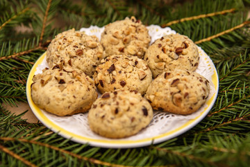 Coconut Christmas cookies on a plate surrounded by fir branches