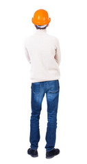 Backview of an engineer in construction helmet stands.
