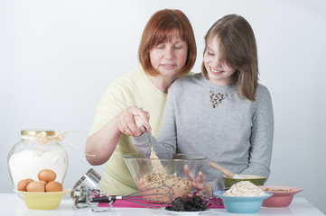 Mom teaches daughter to cook the dough..