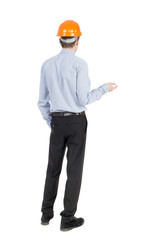 Backview of an engineer in construction helmet stands.