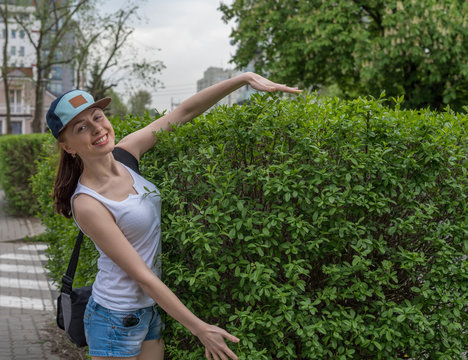 strolling girl in blue cap with green nature on background