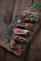 Wooden cutting board with medium rare grilled ribeye steak