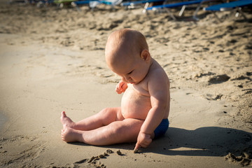 Little baby boy on the beach, playing