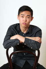 Romantic young Asian man sitting on a chair