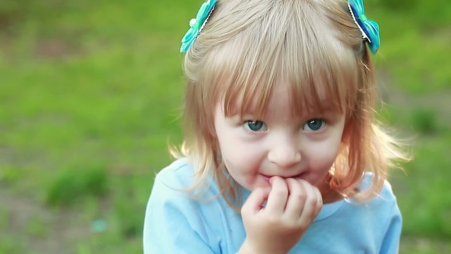 Girl sucking hand on nature