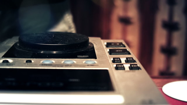 DJ spinning and touching CDJ console mixer faders and knobs