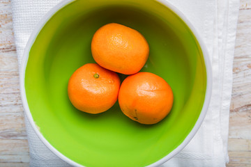 Tangerines in a bowl on a white wood