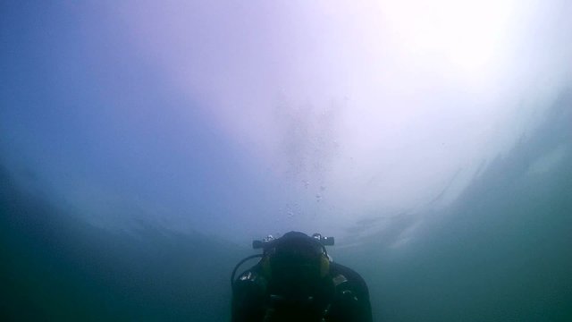 Diver with the metal detector searching for underwater  